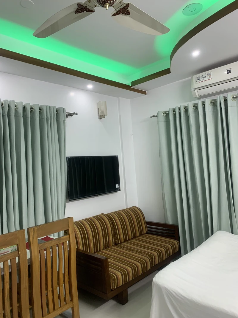 Furnished 1 room apartment in Dhaka, Property D1-22/D-B4, sitting area with sofa, wall TV, dining chairs and AC